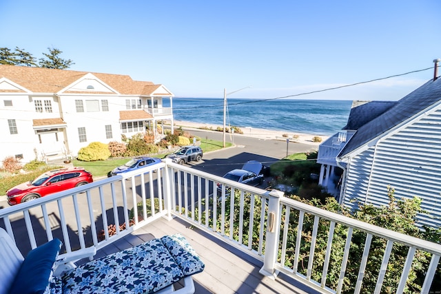 balcony featuring a water view and a beach view