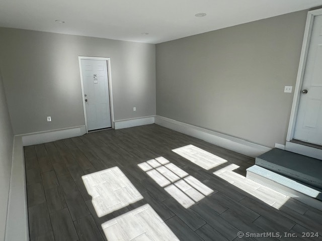 empty room with dark hardwood / wood-style flooring