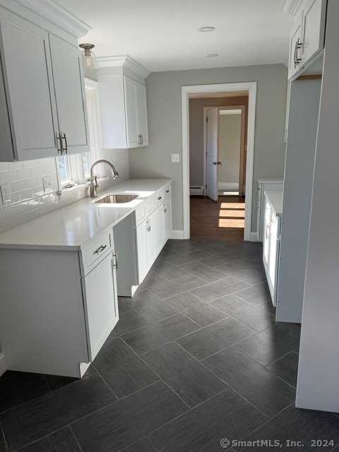 kitchen with white cabinets, tasteful backsplash, and sink