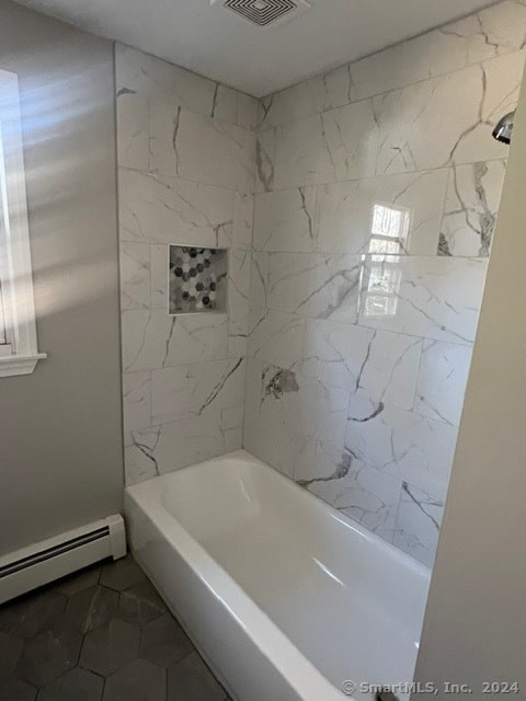 bathroom featuring baseboard heating and tiled shower / bath