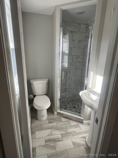 bathroom with toilet and a shower with shower door