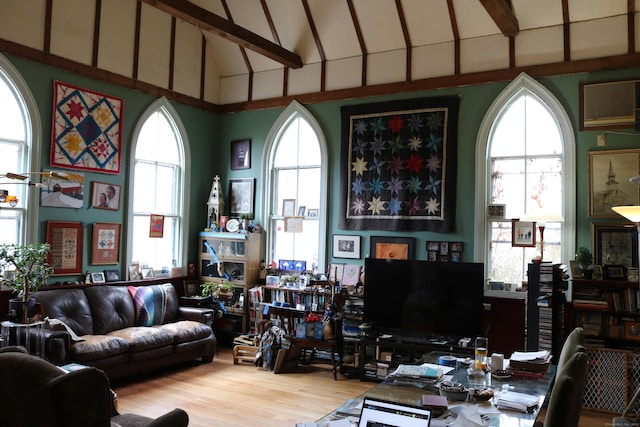 living area with high vaulted ceiling, wood finished floors, beam ceiling, and plenty of natural light