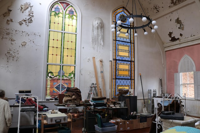 misc room with a chandelier, arched walkways, and a high ceiling
