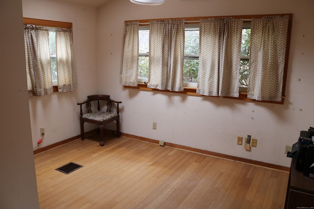 unfurnished room featuring baseboards, wood finished floors, and visible vents