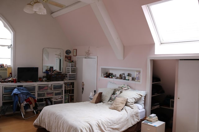 bedroom featuring lofted ceiling with beams and wood finished floors
