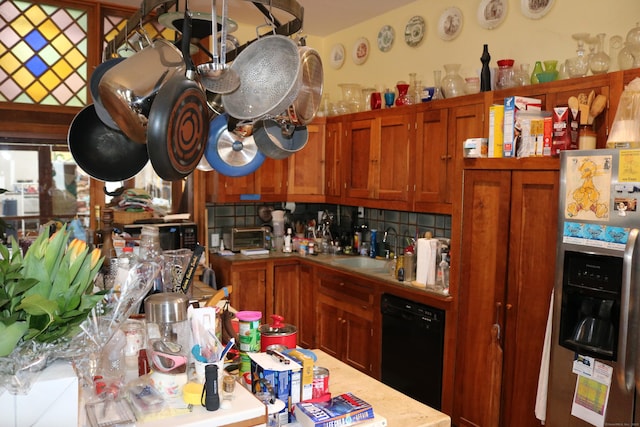 kitchen with a sink, brown cabinetry, dishwasher, light countertops, and stainless steel refrigerator with ice dispenser