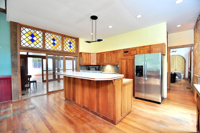 14 River Rd, Cornwall, CT 06796 - kitchen featuring stainless steel fridge with ice dispenser, light wood-style floors, a towering ceiling, light countertops, and a kitchen island