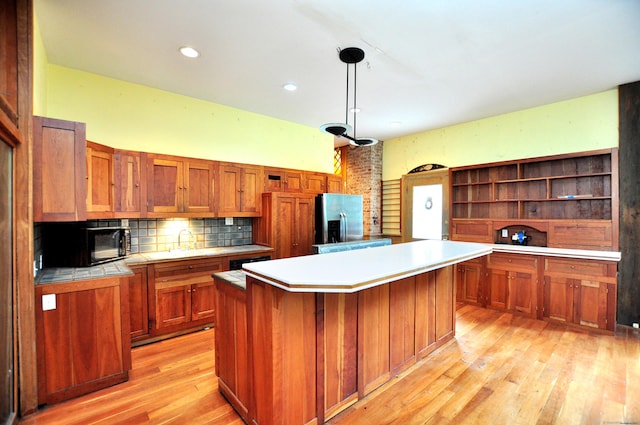 14 River Rd, Cornwall, CT 06796 - kitchen featuring stainless steel fridge, black microwave, brown cabinets, open shelves, and a kitchen island