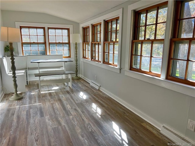 unfurnished dining area featuring wood-type flooring, lofted ceiling, baseboard heating, and a wealth of natural light