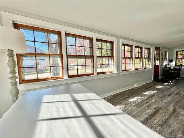 unfurnished bedroom featuring dark hardwood / wood-style floors and lofted ceiling