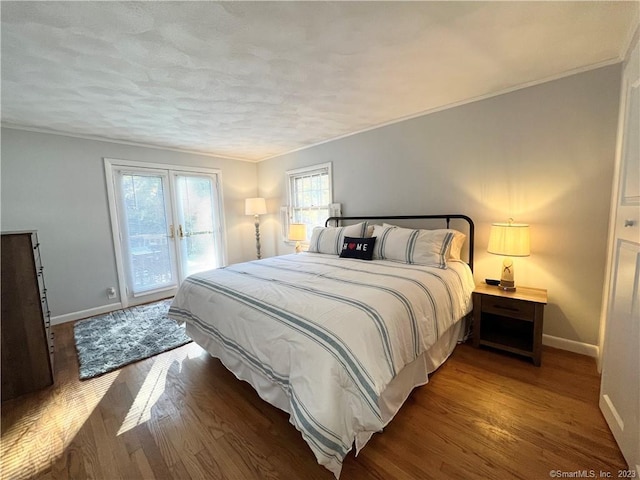 bedroom featuring french doors, dark hardwood / wood-style flooring, access to outside, and crown molding