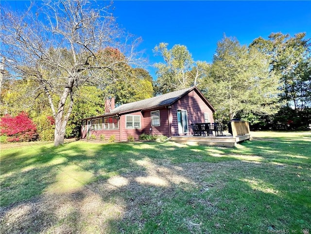 view of side of home featuring a lawn and a wooden deck