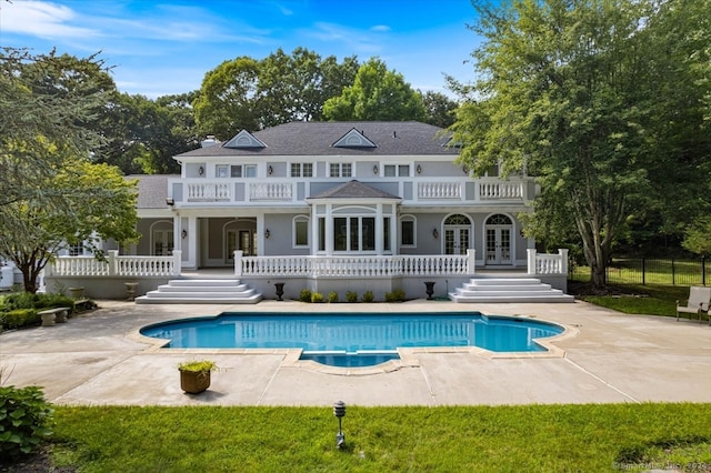 rear view of house featuring a patio area, a balcony, and french doors