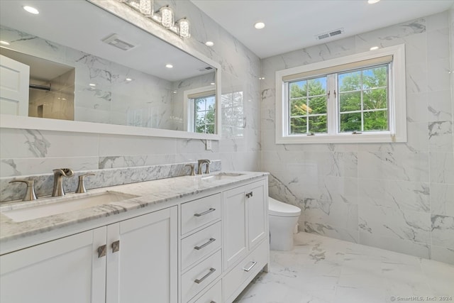 bathroom with vanity, tile walls, and toilet