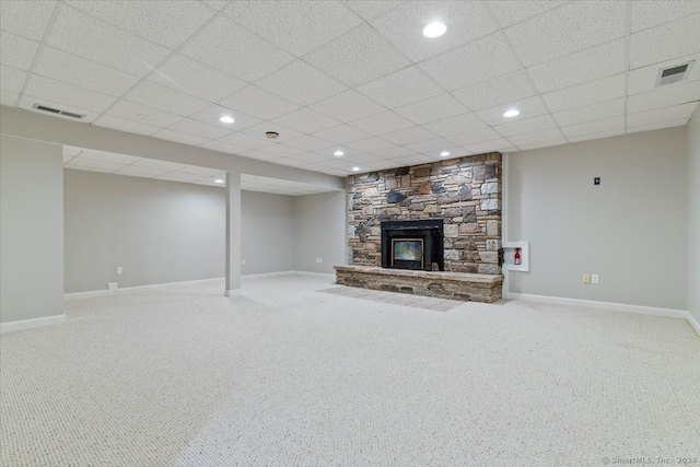 unfurnished living room featuring carpet flooring, a paneled ceiling, and a fireplace