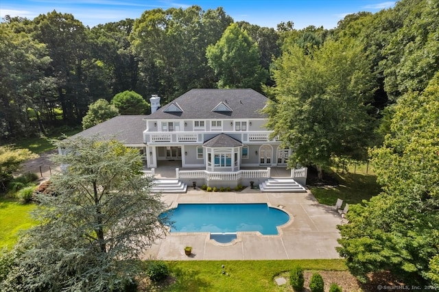 rear view of house with french doors, a patio, and a balcony