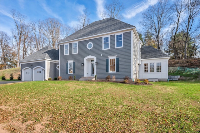 colonial house with a front yard and a garage