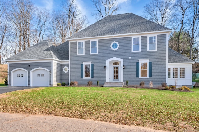 colonial inspired home featuring a front lawn and a garage