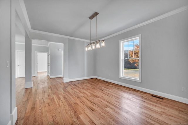 unfurnished dining area with ornamental molding and light wood-type flooring