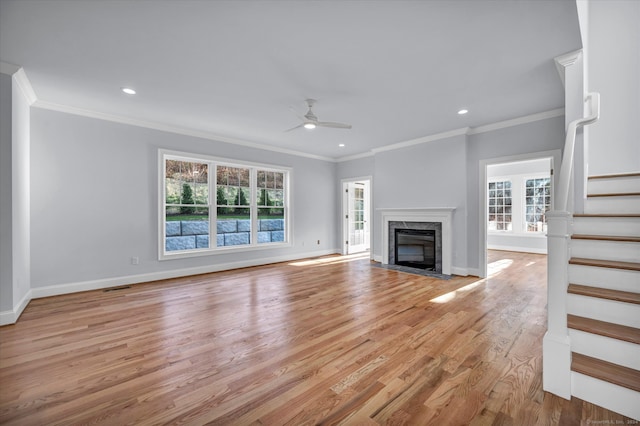 unfurnished living room with a fireplace, ceiling fan, light hardwood / wood-style flooring, and ornamental molding