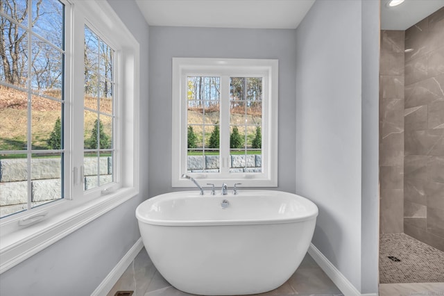 bathroom featuring tile patterned floors, plus walk in shower, and a healthy amount of sunlight