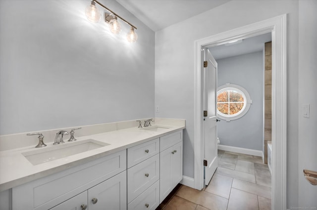 bathroom with tile patterned floors, a bathing tub, vanity, and toilet