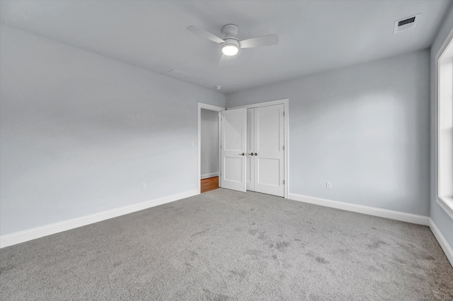 unfurnished bedroom with ceiling fan, a closet, and carpet floors