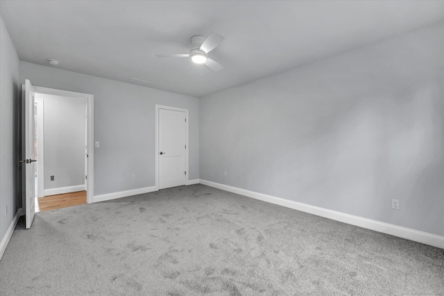 carpeted spare room featuring ceiling fan