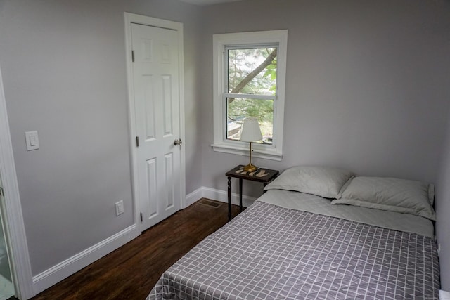 bedroom with dark hardwood / wood-style floors