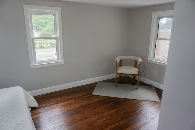 living area featuring plenty of natural light and dark hardwood / wood-style floors