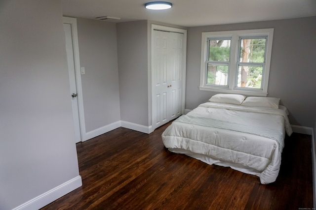 bedroom with a closet and dark hardwood / wood-style flooring