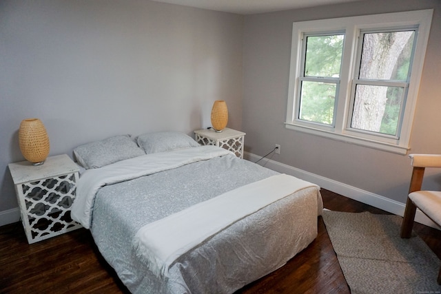 bedroom with dark hardwood / wood-style floors