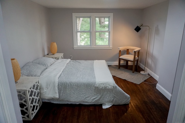 bedroom with dark hardwood / wood-style floors