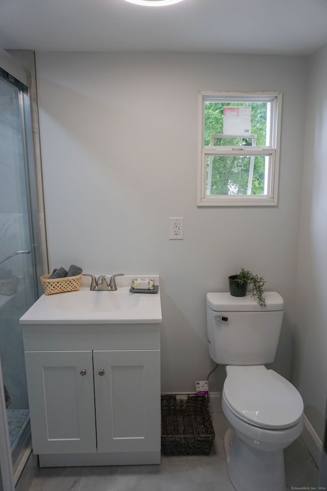 bathroom featuring tile patterned flooring, vanity, an enclosed shower, and toilet