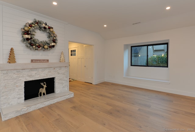 unfurnished living room featuring wood-type flooring, a fireplace, and vaulted ceiling