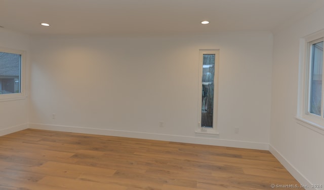 empty room with light hardwood / wood-style flooring and crown molding