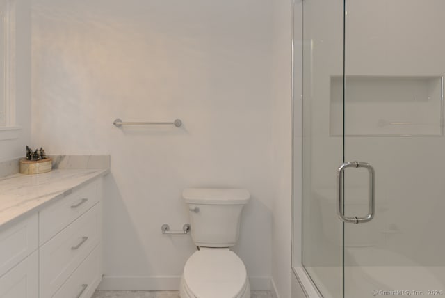 bathroom featuring vanity, toilet, and an enclosed shower