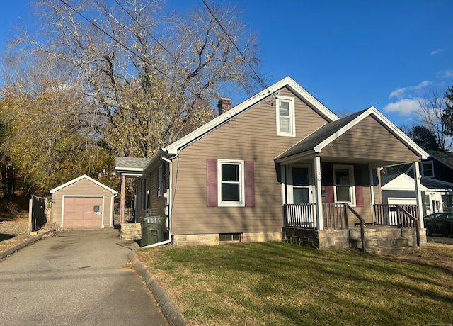 bungalow with covered porch, a garage, an outdoor structure, and a front yard