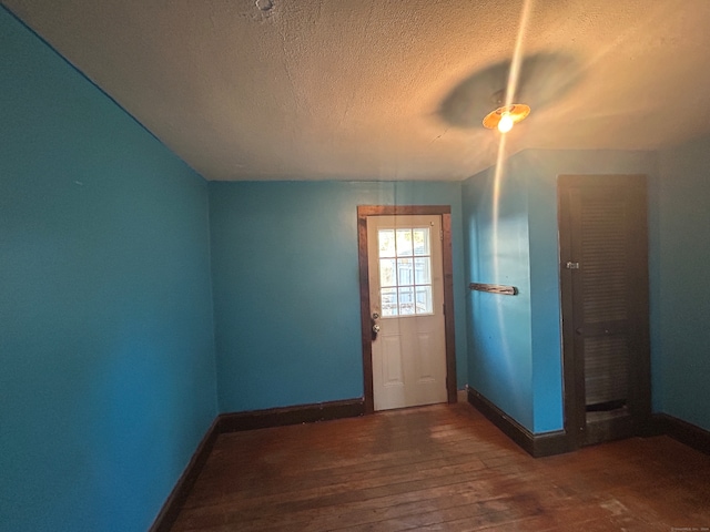 doorway to outside featuring a textured ceiling, dark hardwood / wood-style floors, vaulted ceiling, and ceiling fan