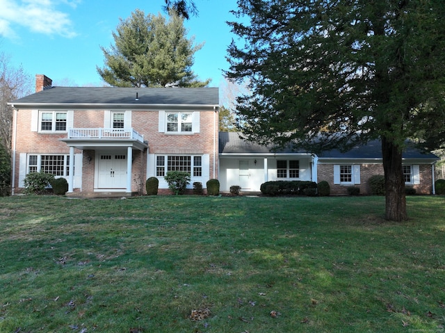 view of front of home with a front yard and a balcony