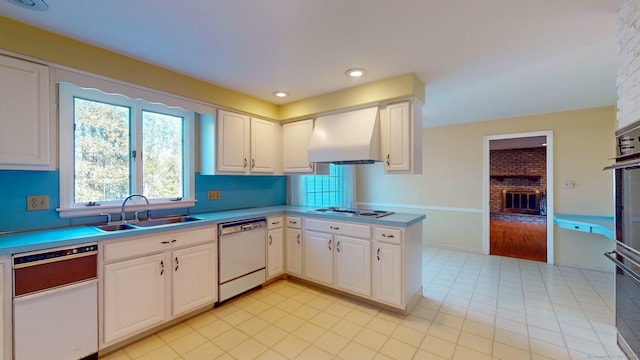 kitchen featuring custom exhaust hood, white appliances, white cabinets, sink, and kitchen peninsula