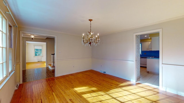 unfurnished room with light hardwood / wood-style flooring and a chandelier