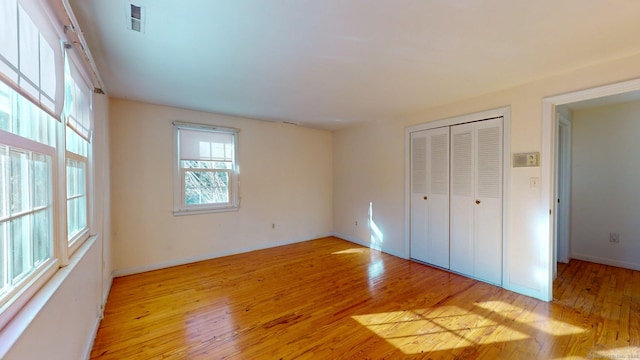 unfurnished bedroom with a closet and light hardwood / wood-style flooring