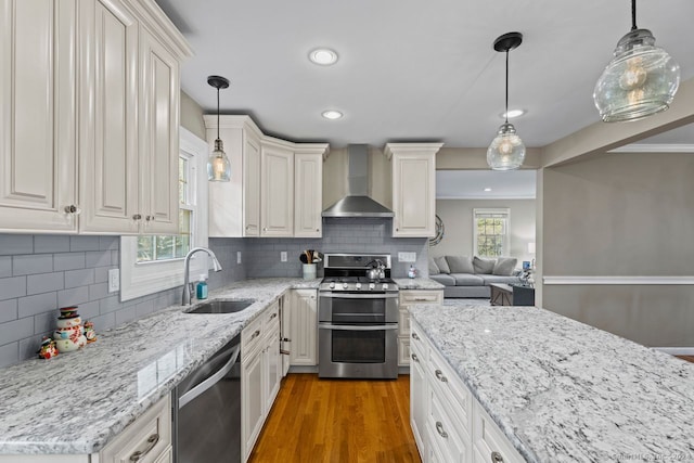 kitchen featuring sink, wall chimney exhaust hood, plenty of natural light, and appliances with stainless steel finishes