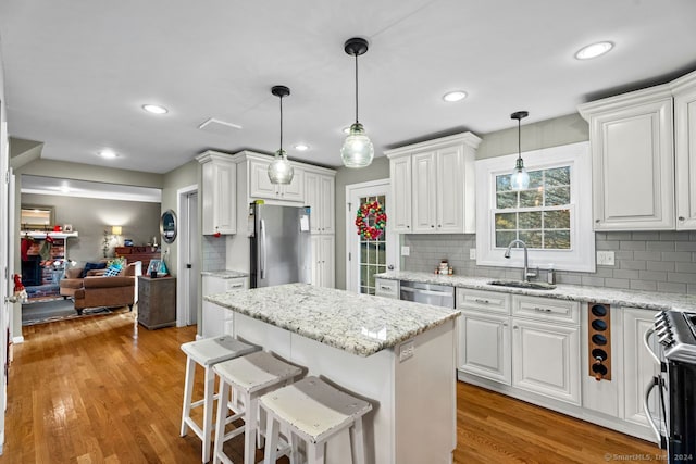 kitchen featuring white cabinets, stainless steel appliances, light hardwood / wood-style flooring, and sink