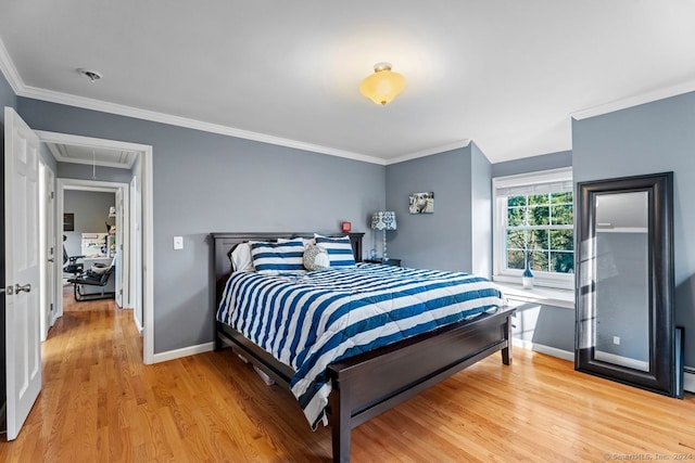 bedroom with crown molding and light wood-type flooring