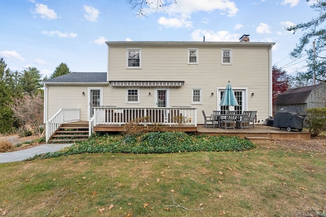 rear view of property with a wooden deck and a yard