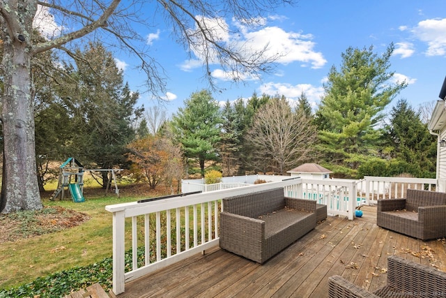 wooden terrace featuring a playground and a yard