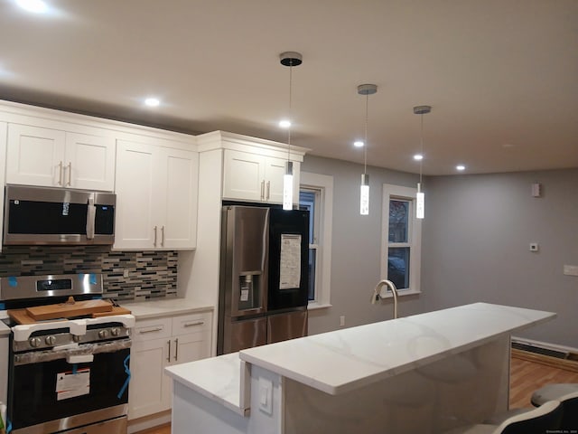 kitchen with a center island, stainless steel appliances, and white cabinetry