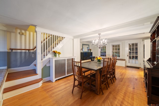 dining room with light wood-type flooring and a chandelier